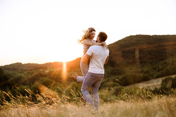 istock Joyful couple in meadow at sunset 2227856251