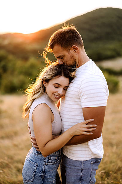 istock Romantic couple embracing in meadow during golden hour 2227856255