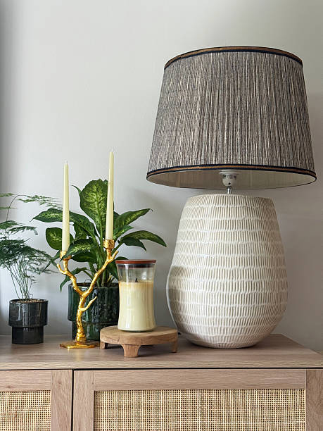 istock Image of large ceramic table lamp with oversized beige and brown lampshade / statement furniture piece surrounded by house plants 2227857440