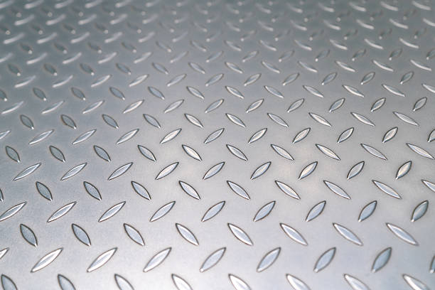 Dirty gray metal industrial anti slip embossed steel stairs with diagonal bumps of diamond pattern texture