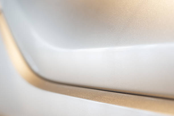 A detailed close-up view of a metallic surface featuring soft curves, a sleek finish, and a gradient lighting effect, emphasizing minimalism and modern design. Perfect for abstract and industrial-themed projects.