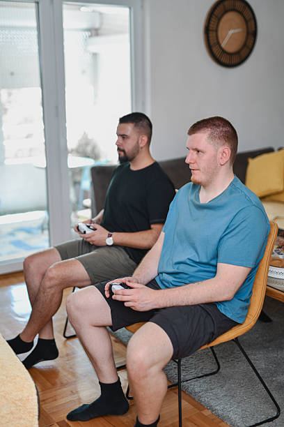 istock Male Roommates Sharing Joyful Gaming Moment While Immersed In Vibrant Virtual World 2227861757