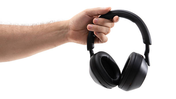 istock Hand holds black headphones on a white background 2227863307