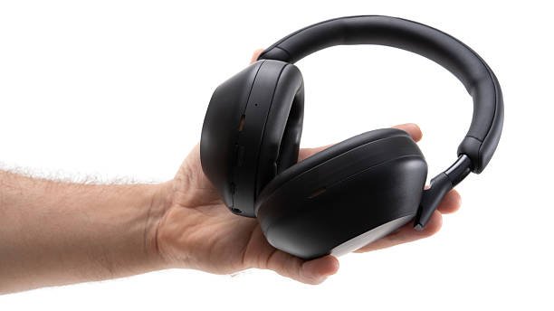 istock Hand with wireless headphones in light 2227863310