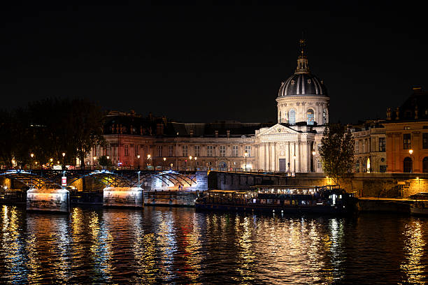 Paris : Institut de France, by night, on Seine quayside, with Pont des Arts