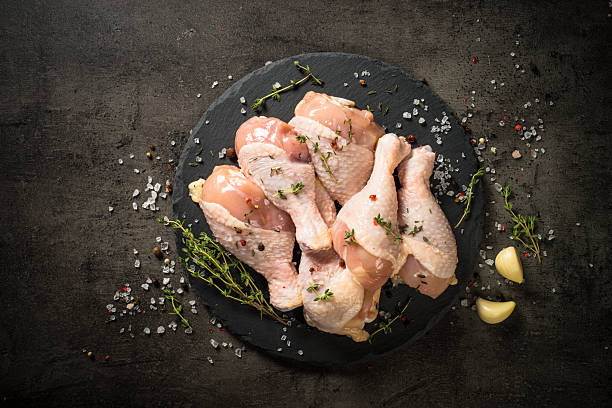 istock Chicken drumsticks with herbs at black. 2227868572