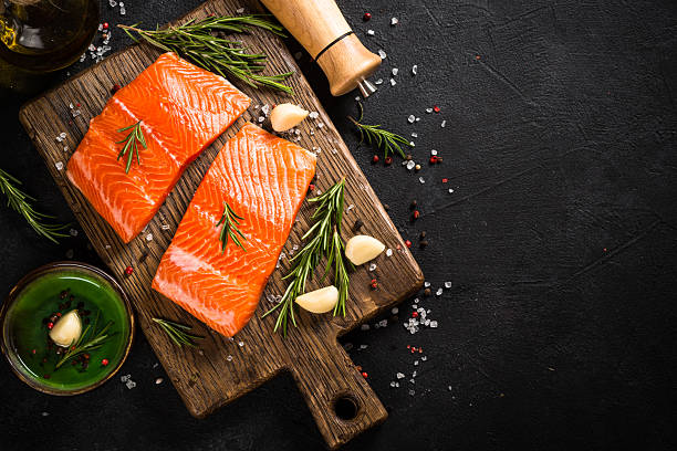 istock Salmon fish with ingredients at black table. 2227868745