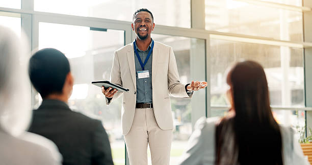 istock Tablet, businessman and presentation in conference room with team at financial workshop. Tech, smile and presenter in office meeting for economy growth, investment planning or training with proposal 2227869535