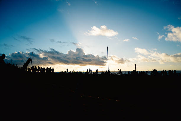 istock Several unidentified people, silhouetted against clouds and a blue sky in the background. Dramatic sunset. Winter season. 2227872896