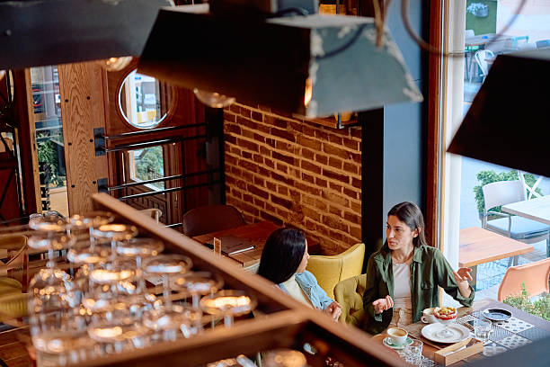 istock Two Young Women Talking and Having Breakfast in a Cafe 2227876988