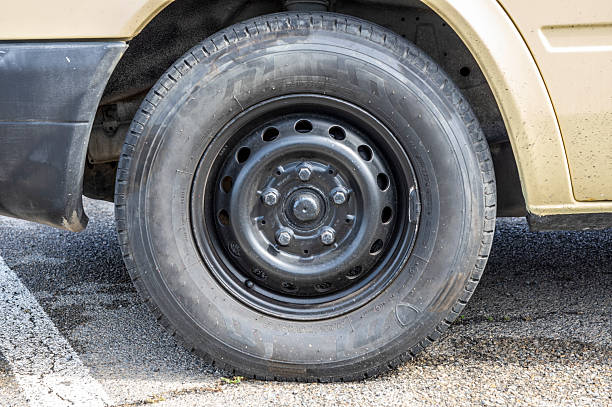 istock Old van wheel on asphalt - old camper tire 2227880400