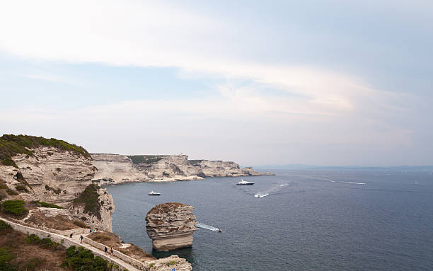 A breathtaking coastal scene featuring high cliffs. The serene atmosphere captures a perfect blend of natureal beauty and human recreation. Bonifacio, Corsica