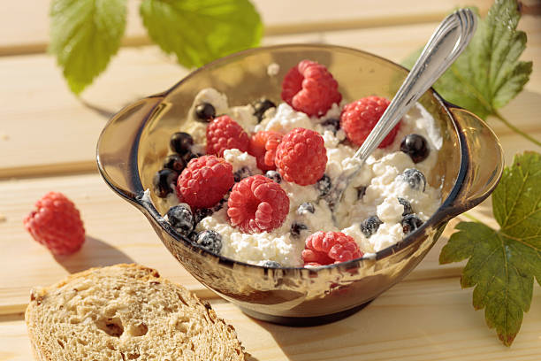 Ricotta or cottage cheese with fresh raspberries and  black currant. A simple country breakfast, natural morning sunlight.