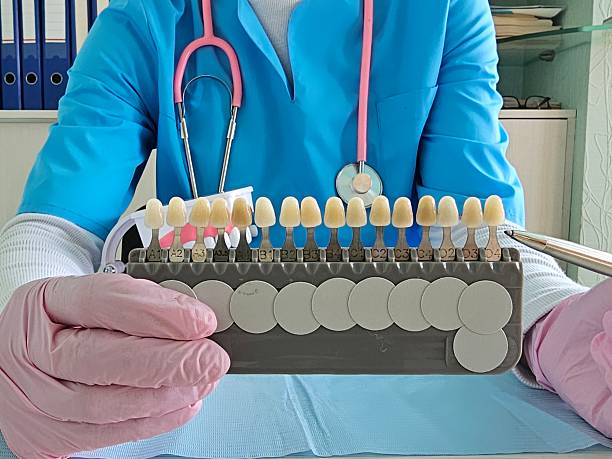 istock Dental professional demonstrates shade guide for teeth 2227888612
