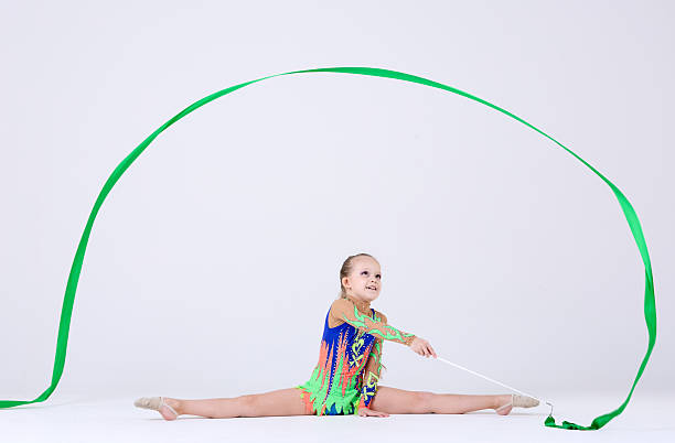 Poster. Contemporary art collage. Rhythmic gymnast elegantly twirls ribbon, highlighted by bold pink outlines and dynamic graphic elements. Grainy fabric effect. Concept of sport, active games, motion