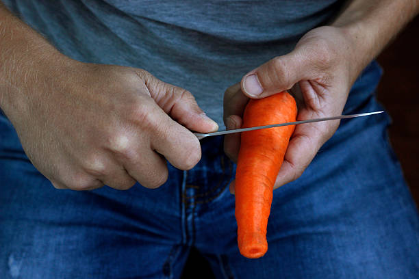 istock carrot in hand, man holding carrot in hand 2227895115