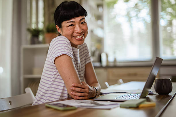 istock Smiling asian freelancer working from home using laptop 2227898160