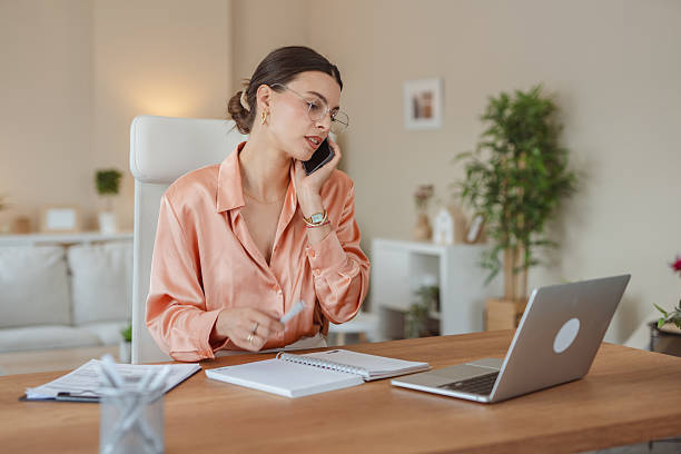 istock Businesswoman working from home talking on phone and taking notes 2227899670