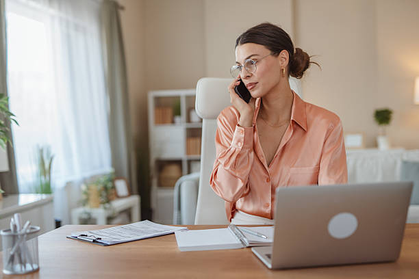 istock Businesswoman working from home talking on phone and taking notes 2227899672