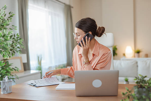 istock Businesswoman working from home talking on phone and taking notes 2227899682