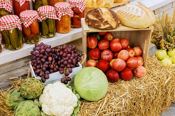 Baskets apples, grapes, vegetables alongside loaves of bread in cozy market full seasonal delights.