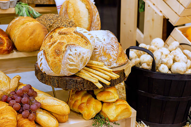 Freshly baked bread pastries displayed in rustic bakery setting during afternoon hours