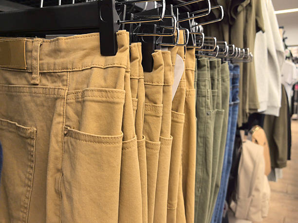 istock Neutral-toned pants displayed in a chic clothing store during a busy weekend 2227906357
