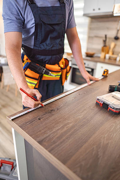istock Carpenter measuring wooden kitchen countertop using tape measure and pencil 2227906754