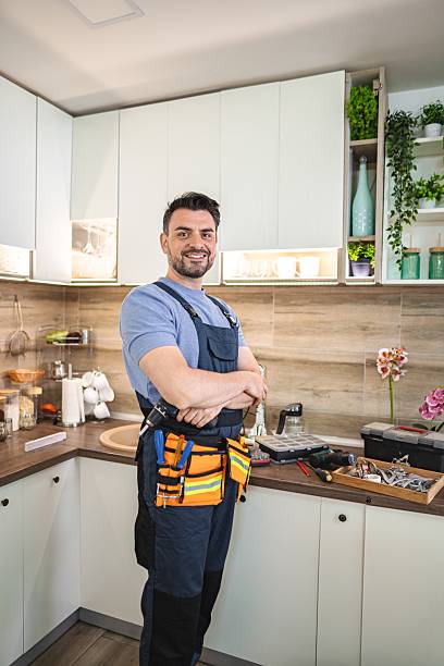 istock Handyman smiling with arms crossed in kitchen with tools on counter 2227906863