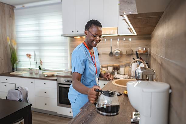 istock Smiling Female Doctor Pouring Coffee at Home After Work 2227906976