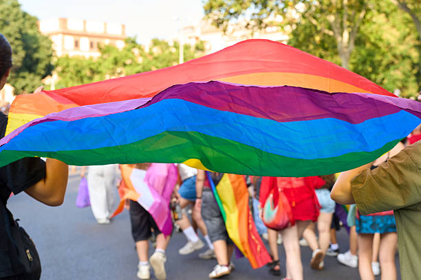istock People holding rainbow flag at pride parade celebrating lgbtq+ rights 2227908347