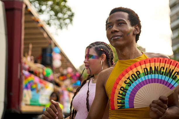 istock Young man with rainbow fan enjoying pride parade 2227908377