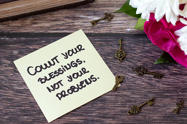 istock Count your blessings, not your problems, handwritten quote with ancient keys and holy bible on wooden table 2227910440