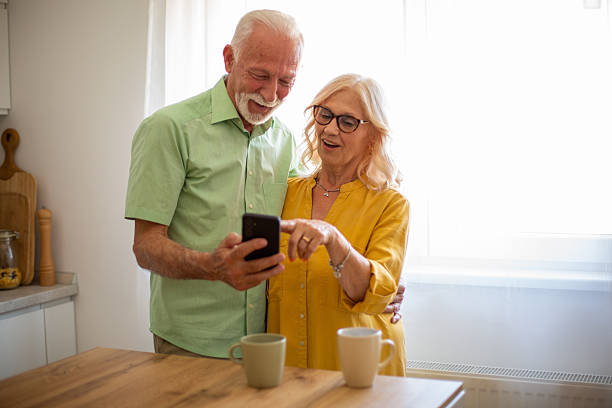 istock Happy senior couple using smartphone at home in the kitchen 2227911684