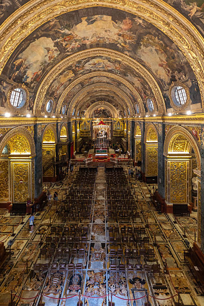 Valletta, Malta – June 21, 2021: Wide view of richly decorated nave and ceiling frescoes in St John Co-Cathedral.