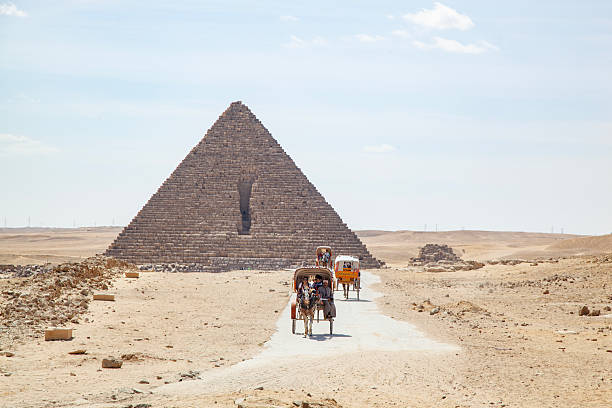 Tourists touring the pyramids in a horse-drawn carriage Giza area , Cairo, Egypt- March 15, 2024 Tourists visit the pyramids with horse-drawn carriage. arab man riding horse stock pictures, royalty-free photos & images