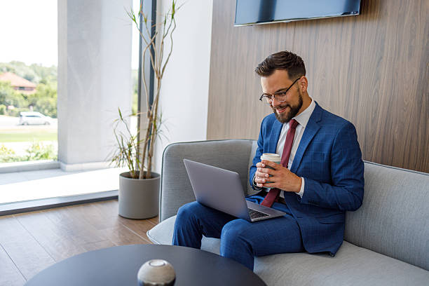 istock Businessman working on laptop and drinking coffee in office lobby 2227915604