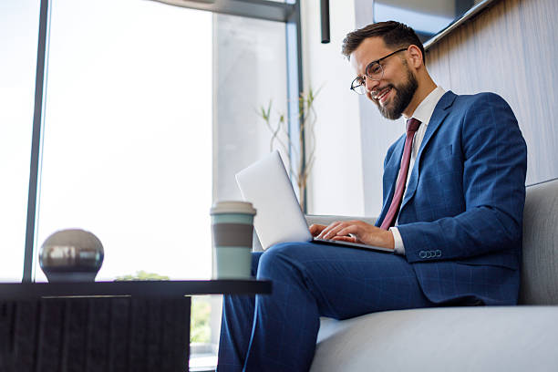 istock Businessman working on laptop in modern office lobby 2227915651