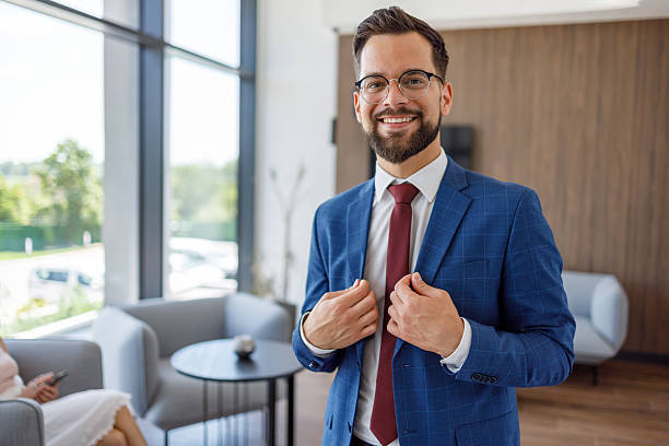 istock Smiling businessman adjusting his jacket in modern office lobby 2227915906