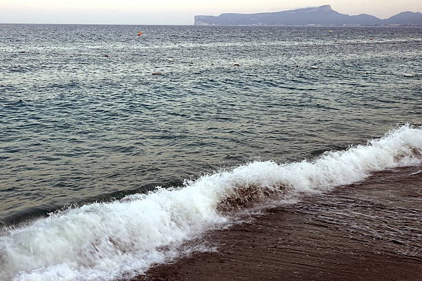 The waves, backlit by the setting sun, can appear golden, pink, or orange, and their white foam adds contrast and dynamics. In calm weather, the waves can be gentle and smooth, but in windy weather they can be more stormy and foamy, creating a breathtaking play of light and shadow.