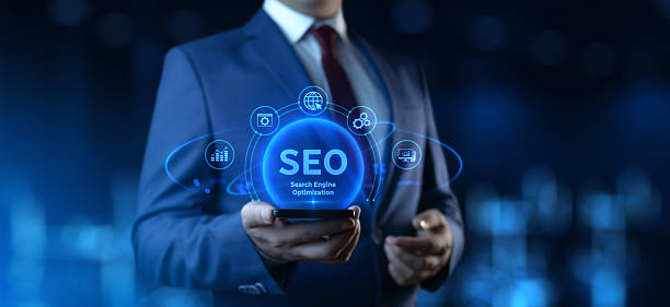 istock Businessman holding smartphone with Search Engine Optimization SEO icons on screen - Digital Marketing Concept 2227921771