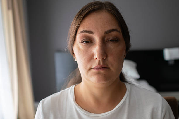 istock Sad woman suffering from depression sitting on bed at home 2227924412