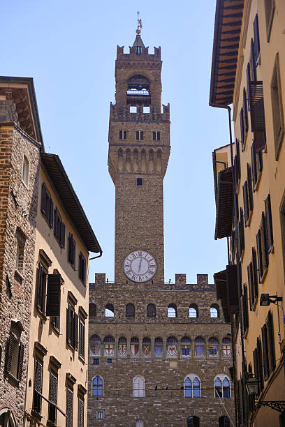 istock Palazzo Vecchio clock tower between old buildings in Florence 2227932613
