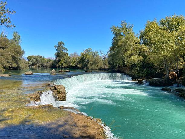 istock A scenic waterfall flows through a lush, green forest under a clear blue sky.
Concept of: Natural beauty. 2227936462