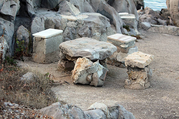 Isolated stone bench on white background, Large bench extracted from whole large stones. Benches for use and outdoor garden or park decorations. Natural colour and texture of stone.