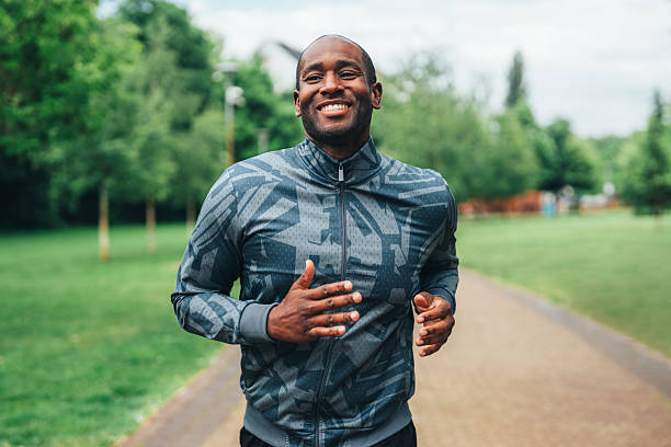 istock Smiling man jogging outdoors in the park. 2227937020
