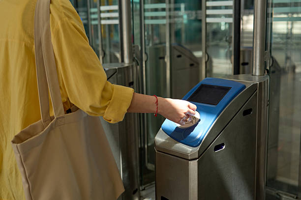 istock Woman using ticket to pass through automatic entry gate at train station 2227937137