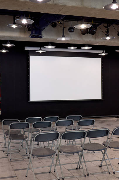istock Empty conference room awaiting a presentation with projector screen and chairs 2227937434