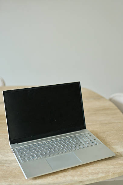 istock Modern silver laptop sits open on wooden table with blank screen 2227938077