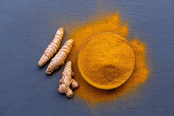 istock Fresh and ground turmeric root on a slate background 2227945224